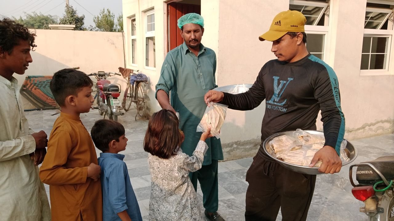 Volunteers distribute food packages to children in community charity effort.